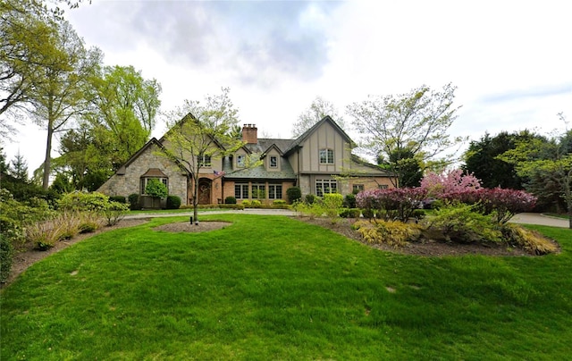 220 Elderfields Rd, Manhasset, NY 11030 - view of front facade with stone siding, a chimney, and a front lawn