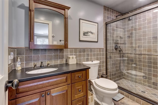 220 Elderfields Rd, Manhasset, NY 11030 - full bathroom with tile walls, a stall shower, vanity, toilet, and a wainscoted wall
