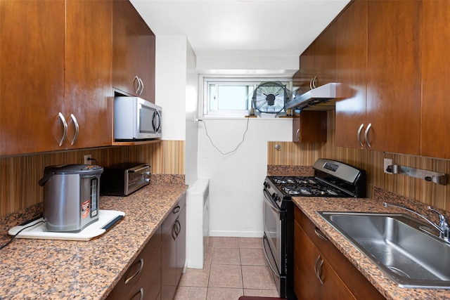 215 Park Row Unit 8B, New York Manhattan, NY 10038 - kitchen with appliances with stainless steel finishes, a sink, under cabinet range hood, light tile patterned flooring, and baseboards