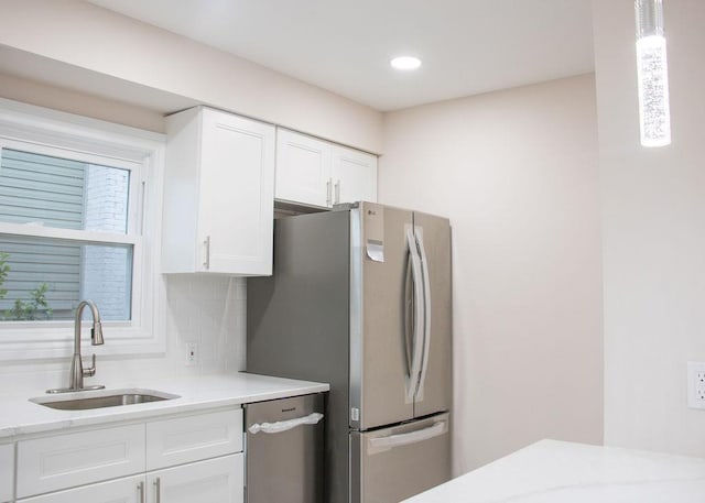 11 Shine Pl, Valley Stream, NY 11581 - kitchen featuring a sink, appliances with stainless steel finishes, white cabinets, backsplash, and decorative light fixtures