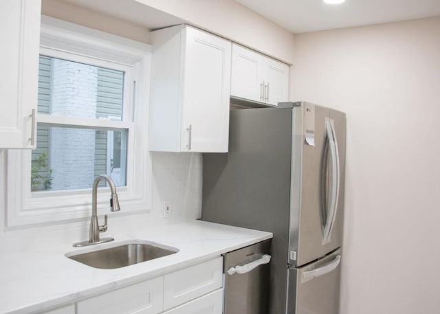 11 Shine Pl, Valley Stream, NY 11581 - kitchen featuring a sink, appliances with stainless steel finishes, white cabinets, backsplash, and light stone countertops