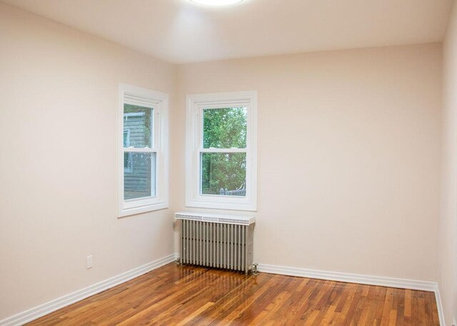 11 Shine Pl, Valley Stream, NY 11581 - spare room with radiator heating unit, wood finished floors, and baseboards