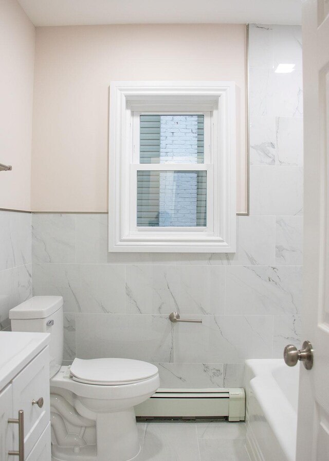 11 Shine Pl, Valley Stream, NY 11581 - bathroom featuring a baseboard radiator, tile walls, toilet, vanity, and wainscoting