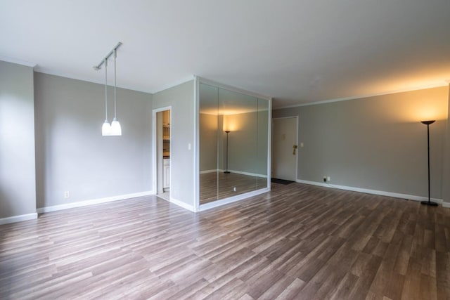 240 Garth Rd Unit 2G2, Scarsdale, NY 10583 - spare room featuring wood finished floors, baseboards, track lighting, and crown molding