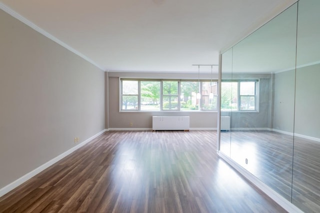 240 Garth Rd Unit 2G2, Scarsdale, NY 10583 - spare room with plenty of natural light, ornamental molding, wood finished floors, baseboards, and radiator