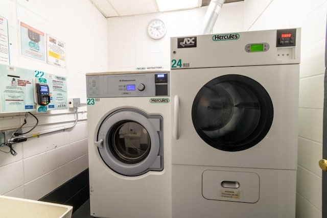 240 Garth Rd Unit 2G2, Scarsdale, NY 10583 - washroom featuring tile walls, washer and clothes dryer, and water heater