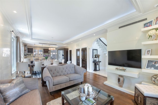 158-44 87th St, Howard Beach, NY 11414 - living room featuring a raised ceiling, crown molding, arched walkways, and wood finished floors