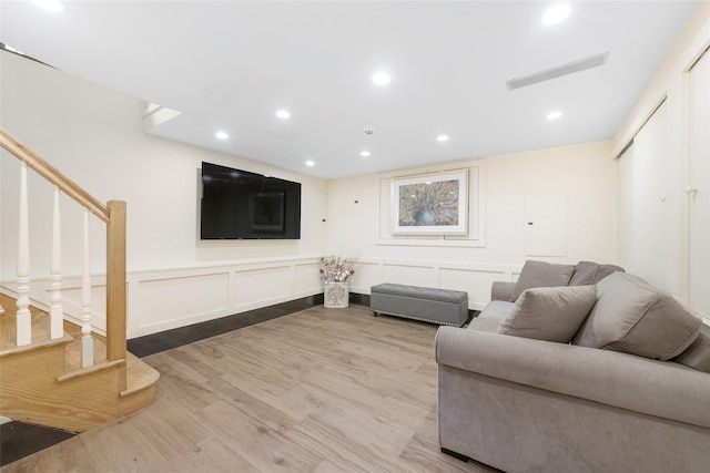 158-44 87th St, Howard Beach, NY 11414 - living area featuring light wood finished floors, stairs, recessed lighting, wainscoting, and a decorative wall