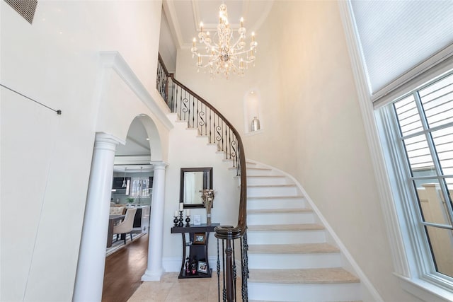158-44 87th St, Howard Beach, NY 11414 - stairs featuring a high ceiling, healthy amount of natural light, ornate columns, a chandelier, and arched walkways