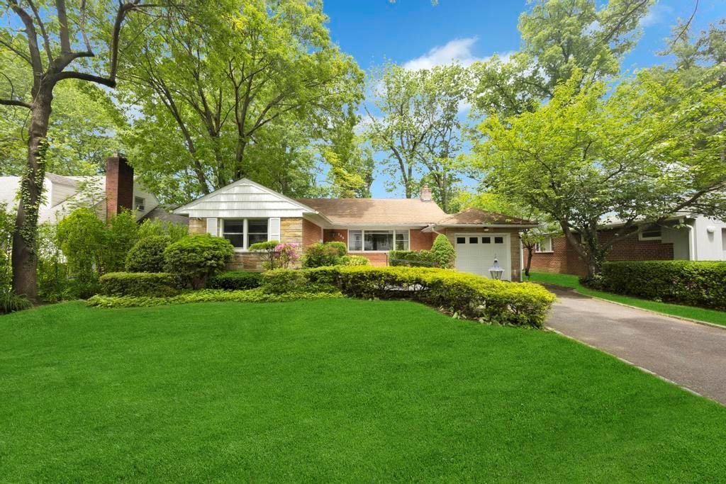 125 Wooleys Ln, Great Neck, NY 11023 - ranch-style home with driveway, a front yard, a garage, a chimney, and brick siding