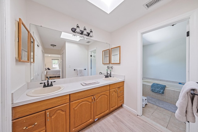 20 Vineyard Way, Mount Sinai, NY 11766 - ensuite bathroom with a skylight, double vanity, and wood finished floors