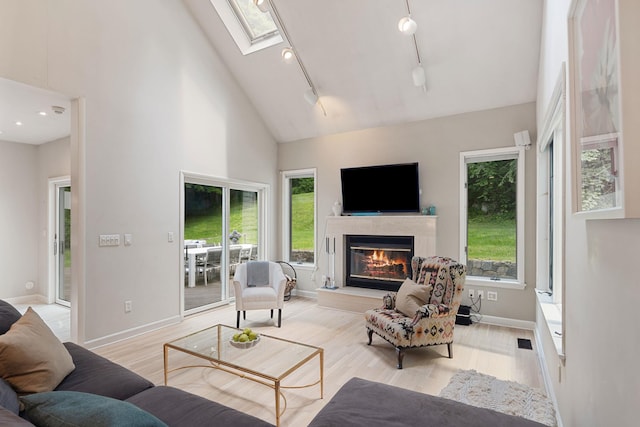43 Random Farms Cir, Chappaqua, NY 10514 - living area with track lighting, a glass covered fireplace, light wood-style floors, healthy amount of natural light, and a high ceiling