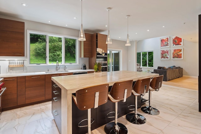 43 Random Farms Cir, Chappaqua, NY 10514 - kitchen featuring light marble finish flooring, butcher block countertops, a center island, brown cabinets, and plenty of natural light