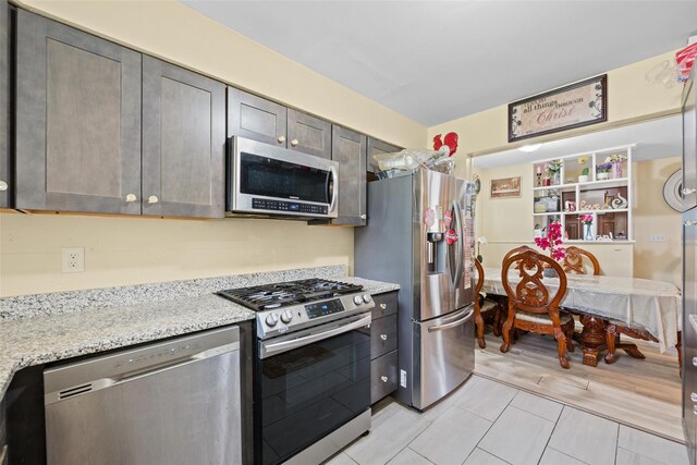 37 Prospect St, Garnerville, NY 10923 - kitchen with appliances with stainless steel finishes, light tile patterned floors, and light stone counters