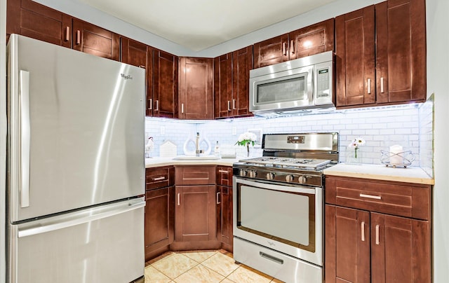 42-30 Douglaston Pkwy Unit 7H, Douglaston, NY 11363 - kitchen with appliances with stainless steel finishes, light countertops, backsplash, and light tile patterned flooring
