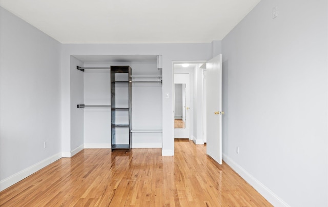 42-30 Douglaston Pkwy Unit 7H, Douglaston, NY 11363 - unfurnished bedroom with light wood-style floors, baseboards, and a closet