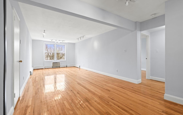 42-30 Douglaston Pkwy Unit 7H, Douglaston, NY 11363 - spare room with track lighting, light wood-style floors, baseboards, a wall unit AC, and a baseboard heating unit