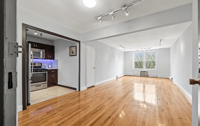 42-30 Douglaston Pkwy Unit 7H, Douglaston, NY 11363 - unfurnished living room with track lighting, light wood-style flooring, and baseboards