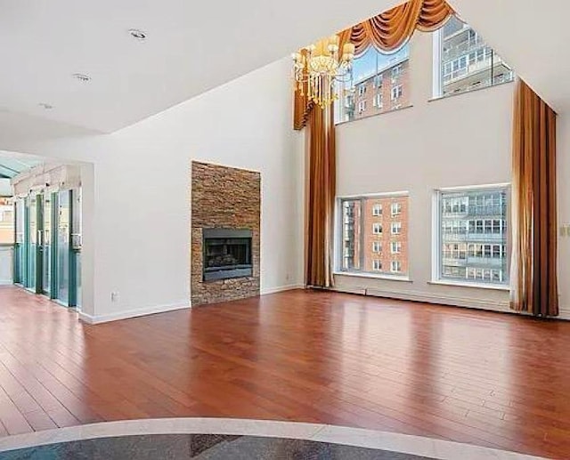 42-31 Colden St Unit R7A, Flushing, NY 11355 - unfurnished living room with hardwood / wood-style flooring, healthy amount of natural light, a towering ceiling, a chandelier, and baseboards