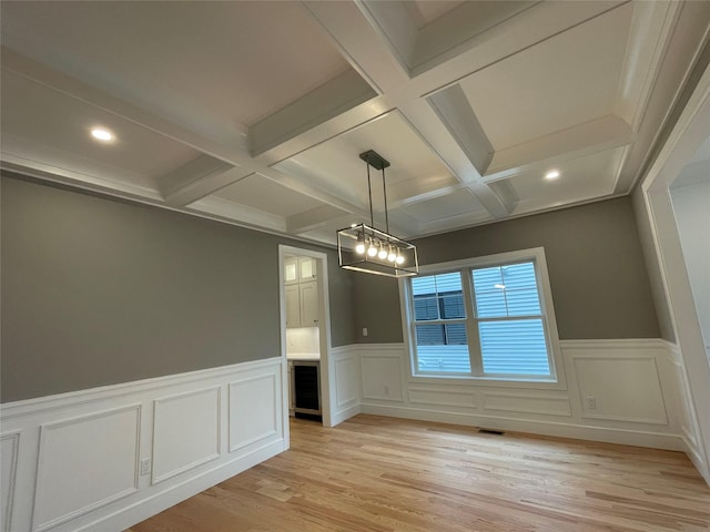 228 Latham Rd, Mineola, NY 11501 - unfurnished dining area featuring coffered ceiling, beamed ceiling, light wood-style floors, recessed lighting, and wainscoting