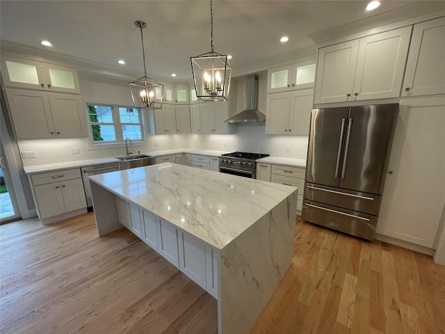 228 Latham Rd, Mineola, NY 11501 - kitchen with wall chimney exhaust hood, premium appliances, a sink, a chandelier, and a kitchen island