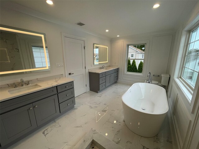 228 Latham Rd, Mineola, NY 11501 - full bathroom featuring plenty of natural light, two vanities, a soaking tub, recessed lighting, and marble finish floors