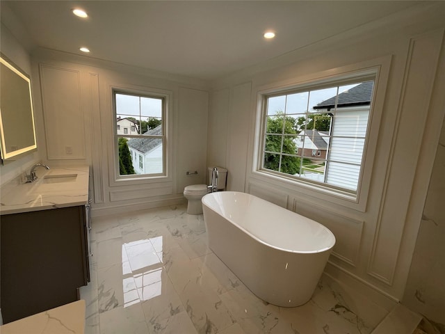 228 Latham Rd, Mineola, NY 11501 - bathroom with healthy amount of natural light, marble look tiles, a freestanding tub, vanity, and recessed lighting
