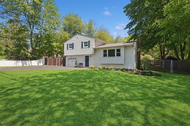 33 Elm St, Lake Ronkonkoma, NY 11779 - tri-level home with a chimney, a garage, and driveway