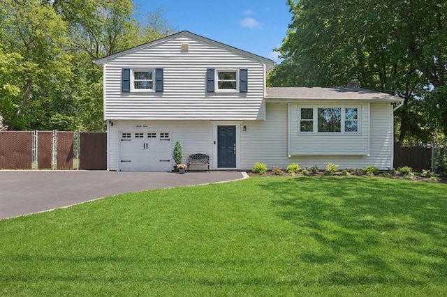 33 Elm St, Lake Ronkonkoma, NY 11779 - tri-level home featuring concrete driveway, an attached garage, and a chimney
