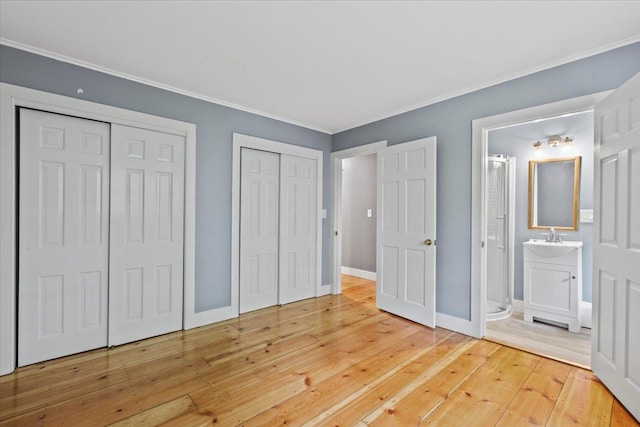 100 Schnackenberg Rd, Call Listing Agent, NY 12075 - unfurnished bedroom featuring two closets, hardwood / wood-style floors, crown molding, ensuite bathroom, and baseboards