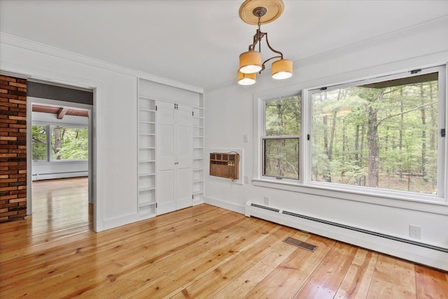 100 Schnackenberg Rd, Call Listing Agent, NY 12075 - unfurnished dining area featuring baseboard heating, an AC wall unit, built in features, light wood-type flooring, and crown molding
