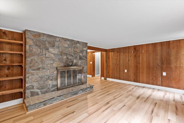 100 Schnackenberg Rd, Call Listing Agent, NY 12075 - unfurnished living room featuring wood finished floors, a stone fireplace, baseboards, and wood walls