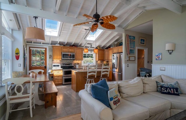 31 Gull Walk, Dunewood, NY 11706 - living area featuring a skylight, a wainscoted wall, a ceiling fan, and light tile patterned floors