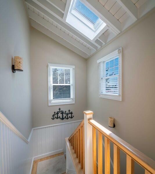 31 Gull Walk, Dunewood, NY 11706 - stairway featuring a wainscoted wall, a skylight, and vaulted ceiling
