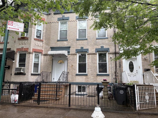 262 Grant Ave, Brooklyn, NY 11208 - townhome / multi-family property with brick siding, a fenced front yard, and cooling unit