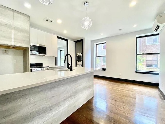 421 E 94th St, Brooklyn, NY 11212 - kitchen featuring a sink, stainless steel microwave, range, modern cabinets, and a wall mounted AC