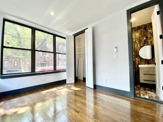 421 E 94th St, Brooklyn, NY 11212 - unfurnished bedroom with wood finished floors, multiple windows, and baseboards