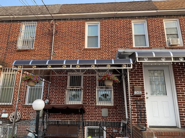 154-02 119th Ave, Jamaica, NY 11434 - view of front facade featuring brick siding, roof with shingles, and cooling unit