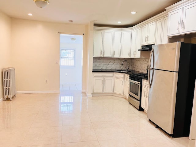 154-02 119th Ave, Jamaica, NY 11434 - kitchen featuring appliances with stainless steel finishes, radiator heating unit, under cabinet range hood, decorative backsplash, and dark countertops