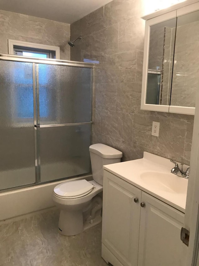 154-02 119th Ave, Jamaica, NY 11434 - full bathroom featuring tile walls, vanity, enclosed tub / shower combo, and toilet