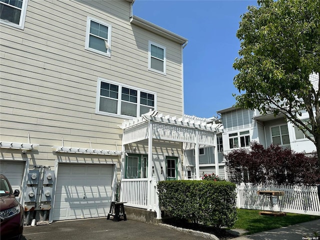 205 Aquatic Pl, Arverne, NY 11692 - rear view of property featuring asphalt driveway and a garage