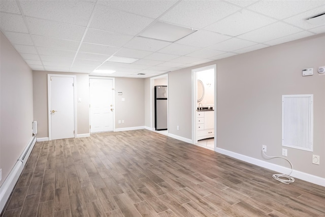 30 Knoll Ln, Glen Head, NY 11545 - unfurnished living room featuring wood finished floors, baseboards, and a drop ceiling