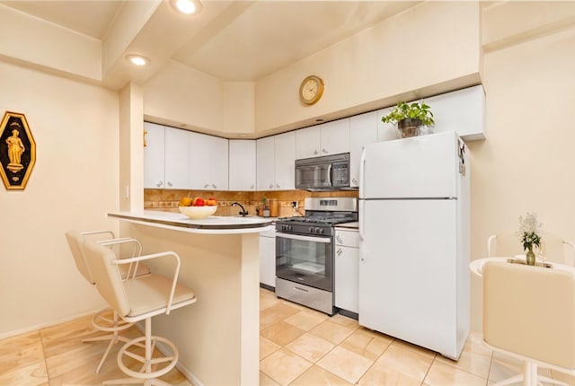 160-15 Powells Cove Blvd Unit D203, Beechhurst, NY 11357 - kitchen featuring appliances with stainless steel finishes, a peninsula, a breakfast bar, white cabinetry, and recessed lighting