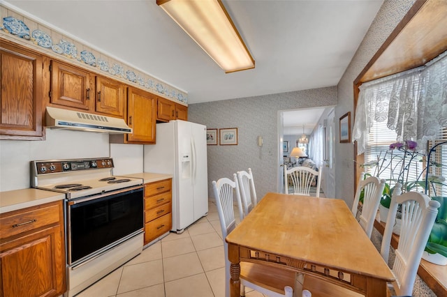 383 Old Country Rd, Deer Park, NY 11729 - kitchen featuring under cabinet range hood, white appliances, wallpapered walls, brown cabinetry, and light countertops
