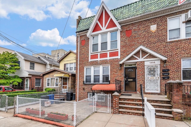 1358 E 35th St, Brooklyn, NY 11210 - view of front facade featuring a gate, a tiled roof, brick siding, and a fenced front yard