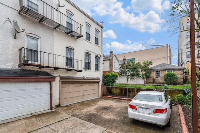 1358 E 35th St, Brooklyn, NY 11210 - view of property featuring an attached garage and concrete driveway