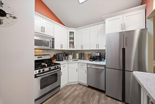 133-20 87th St Unit 3, Ozone Park, NY 11417 - kitchen with appliances with stainless steel finishes, a sink, lofted ceiling, light wood finished floors, and decorative backsplash