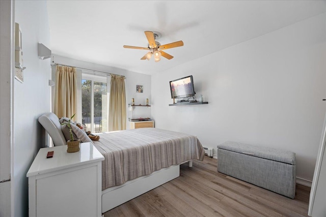 133-20 87th St Unit 3, Ozone Park, NY 11417 - bedroom featuring wood finished floors, a baseboard radiator, and a ceiling fan