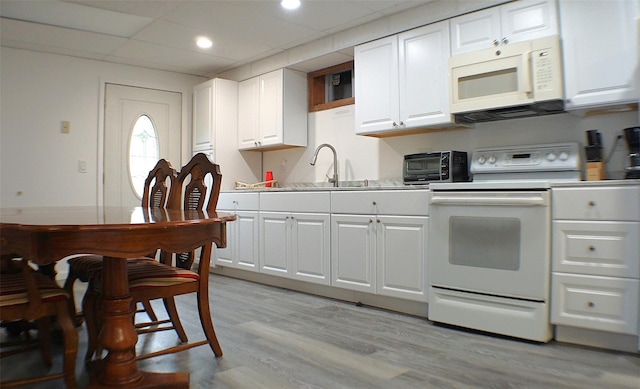26 Saunders Ln, Wawarsing, NY 12489 - kitchen with white appliances, light countertops, white cabinetry, light wood-style flooring, and a sink