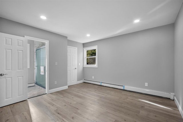 1345 Rte 82, Hopewell Junction, NY 12533 - unfurnished bedroom featuring a baseboard radiator, wood finished floors, baseboards, recessed lighting, and ensuite bath